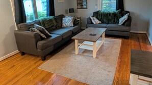 A living room with two sofas, a coffee table, and a rug. - Waldheim Cottage: In-town bar Harbor Hideaway (Bar Harbor)