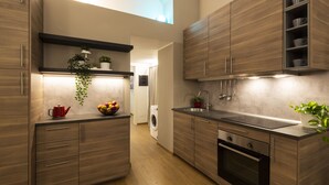 A modern kitchen with wooden cabinets, a built-in oven, and a sink. - notaMi - Voghera Fashion District (Milan)