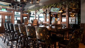 A bar area with wooden chairs, a bar counter, and hanging lights. - The Tynemouth Castle Inn - The Inn Collection Group (North Shields)