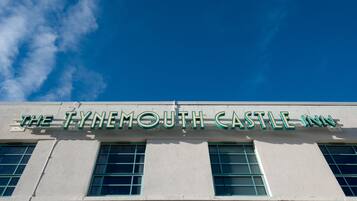 El exterior del The Tynemouth Castle Inn, con un cielo azul despejado de fondo.