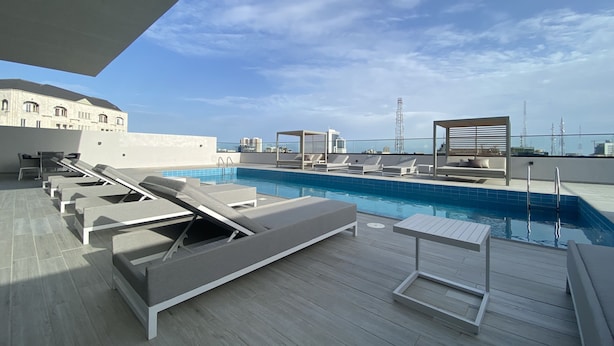 A rooftop pool area with lounge chairs and a pool. - Mastermindsluxuryliving (Lagos)