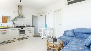 A compact living space with a kitchenette, a dining area, and a sofa.