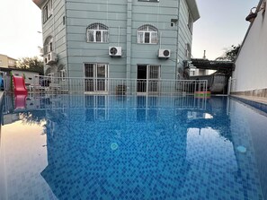 Een seizoensgebonden buitenzwembad en parasols bij het zwembad