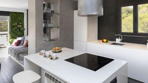 A modern kitchen with a central island, built-in shelves, and a large window. - Apartment Edison by Interhome (Peñiscola)