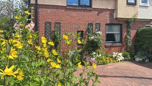 Un bâtiment en briques avec un jardin devant.