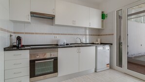 A modern kitchen with white cabinets, a built-in oven, a dishwasher, and a coffee maker. - Esfera I (Santa Cruz)