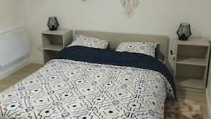 A bedroom with a bed, bedside tables, a window with curtains, a dreamcatcher, and a wall-mounted lamp. - Le Petit Viry, à 20min D'orly (Viry-Châtillon)