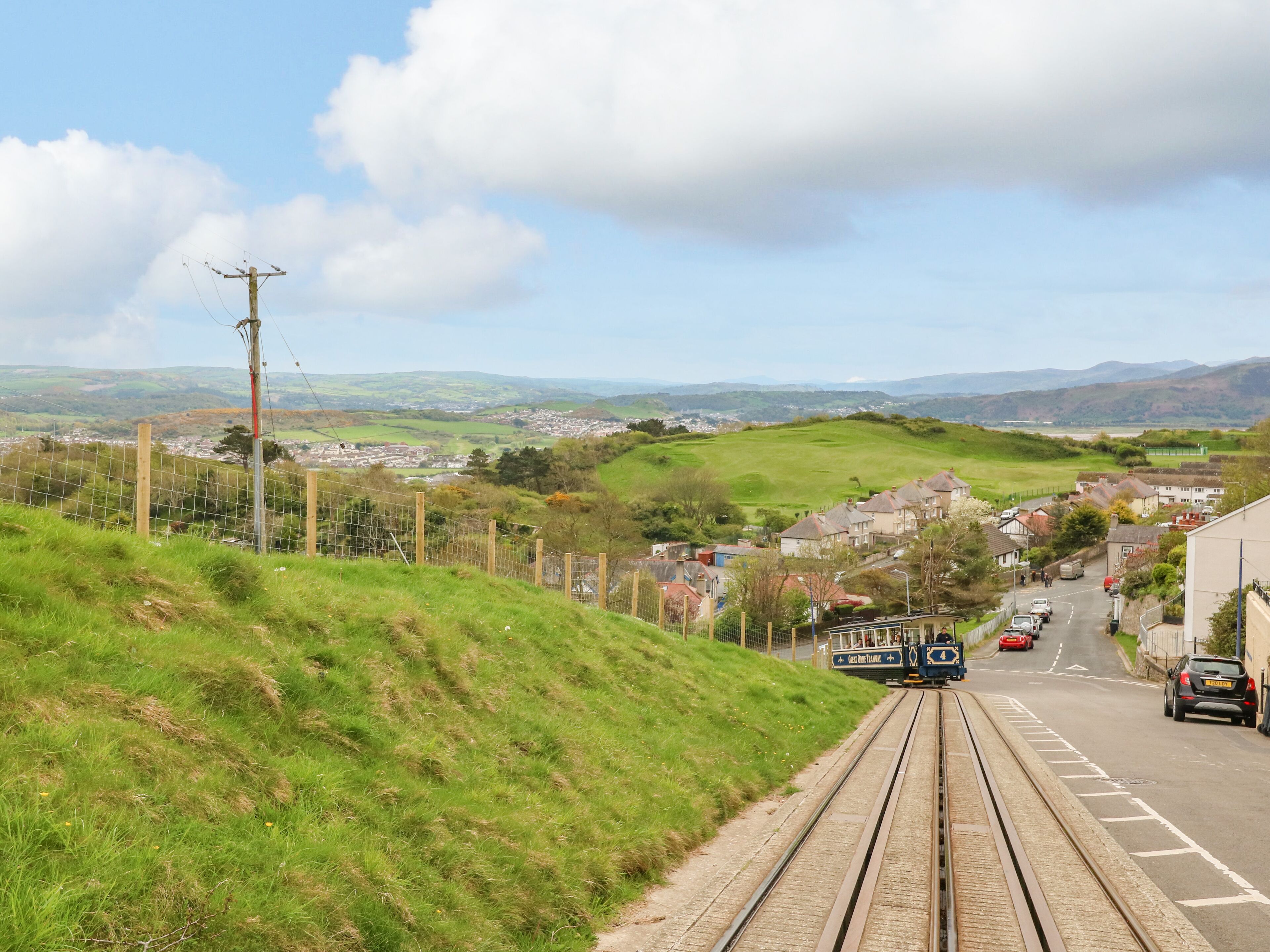A railway track with a train approaching a town.