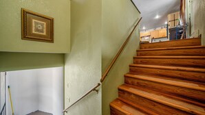 A wooden staircase with a handrail, a picture frame on the wall, and a broom leaning against the wall. - DOWNTOWN DOLORES COLORADO w/river access - Stay at Cozy Comfort Inn, Dolores, CO (Dolores)