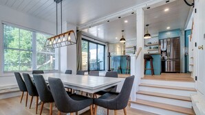 A modern kitchen with a stainless steel refrigerator, a blue countertop, and a hanging light fixture. - 3-bedroom house 915A Shefford mountain view (Bromont)