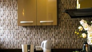 Una cocina moderna con armarios de madera, encimera negra y salpicadero de azulejos.