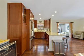 A modern kitchen with wooden cabinets, stainless steel appliances, and a central island. - 401 Wilton Manors in Wilton Manors (Wilton Manors)