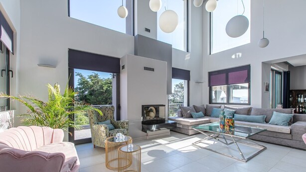 Un salón espacioso con un conjunto de sofá moderno, una mesa de centro y un gran ventanal que proporciona luz natural.