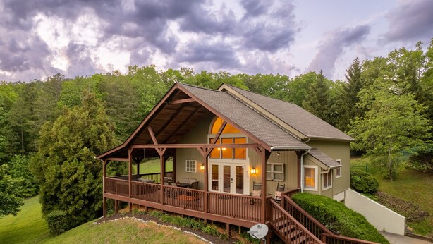 Eine Hütte mit Veranda, Deck und einer Treppe zum Haupteingang.