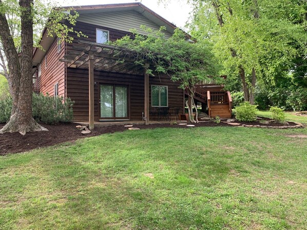 Enjoy a peaceful retreat in this cozy cabin-style house with a covered patio, large window, and comfortable deck.
