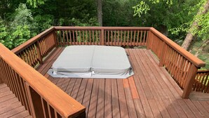 Una terraza de madera con un colchón y un banco.