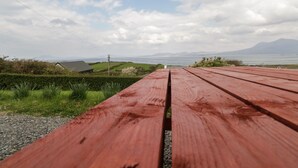 Een houten picknicktafel met uitzicht op een meer en verre bergen.