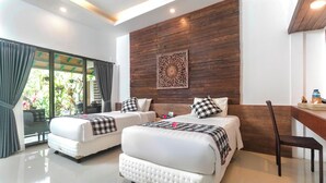 A modern hotel room with two beds, a wooden accent wall, and a view of greenery. - Nawasakti Resort (Ubud)