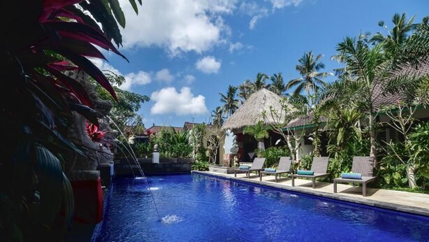 A swimming pool with lounge chairs and palm trees. - Nawasakti Resort (Ubud)