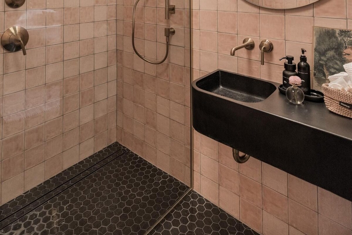 Ein modernes Badezimmer mit Dusche, Waschbecken und Spiegel.