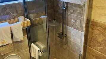 Un baño moderno con ducha de vidrio, inodoro y lavamanos.