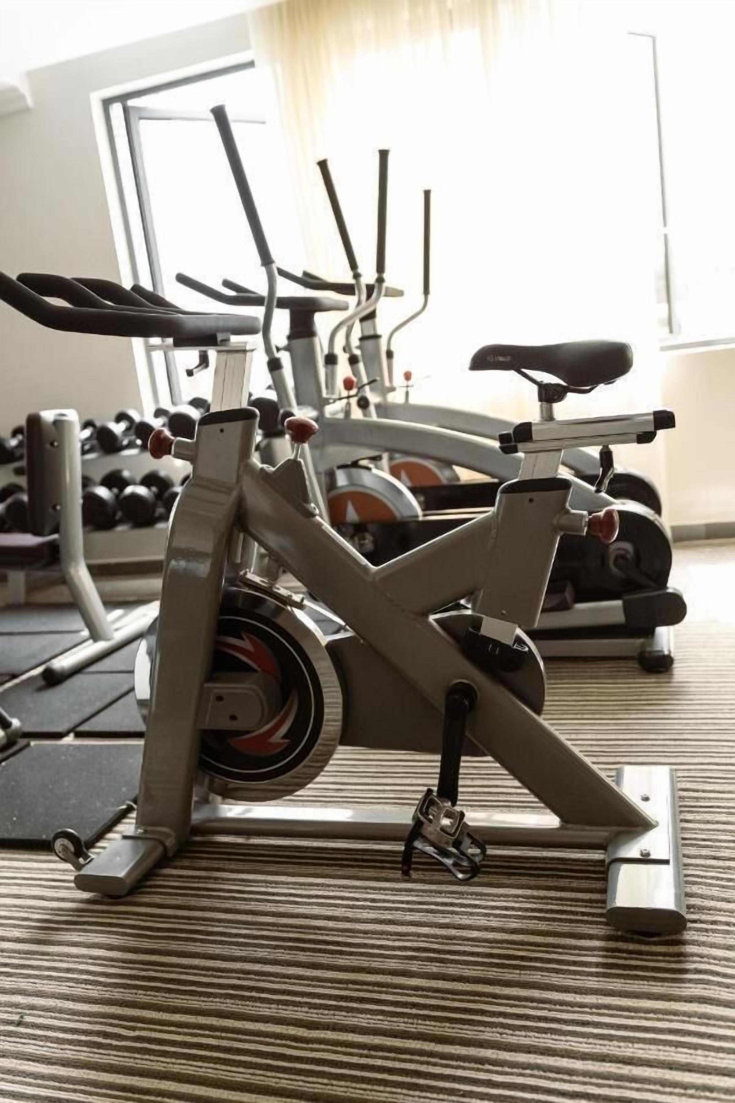 Een hometrainer in een sportschool, met een raam op de achtergrond.