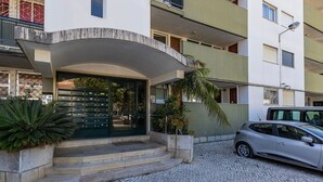 Un edificio con una entrada curva, un buzón y un coche estacionado.