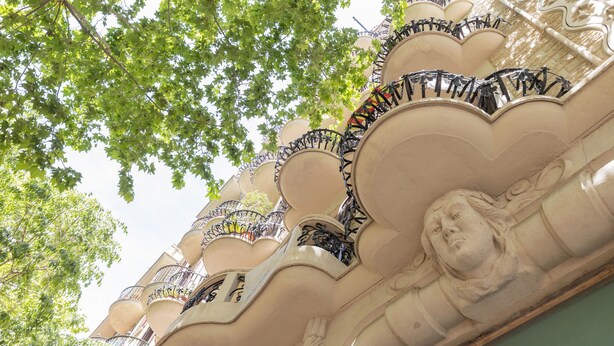 En bygnings facade med dekorative balkoner og klassiske arkitektoniske detaljer.