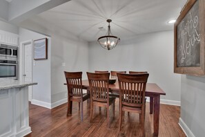 A dining area with a wooden table and chairs, a chandelier, and a chalkboard with "Thank you!" written on it. - Great Home with Southern Charm and Great Space (Frisco)