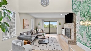 Un salon moderne avec un canapé, un fauteuil, une table basse et une cheminée.