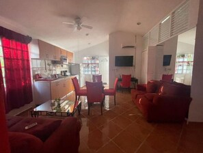 Cozy living space with a kitchen and dining area, featuring a ceiling fan and flat-screen TV.