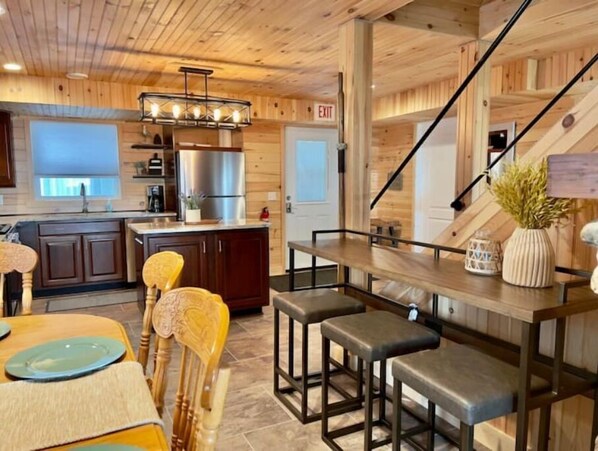 Enjoy cooking in this well-equipped kitchen with a central island, stainless steel appliances, and a dining area.
