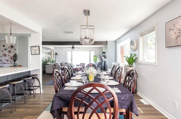 A dining area with a long table set for six, surrounded by chairs.