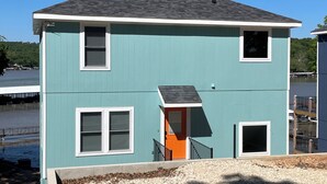 A two-story building with a light blue exterior and a dark roof. - Lake Escape at Station 46 (Gravois Mills)