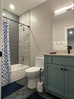 Une salle de bain équipée d’une baignoire, de toilettes et d’un espace douche.