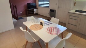 A dining area with a table, chairs, and a television in the background. - Apartamento Hermoso y muy Cómodo (Ushuaia)