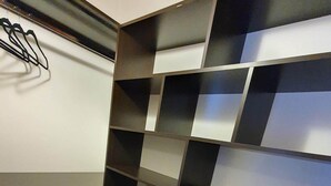 A room with a black and white checkered wall design, a wooden floor, and a white wall with a black logo. - Apartamento Hermoso y muy Cómodo (Ushuaia)