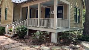 A two-story house with a covered porch, a small front yard, and a brick pathway. - "Nauti-Jayne" coastal cottage in Historic Old Town Bluffton (Bluffton)