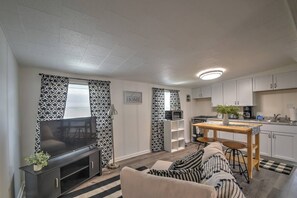 Un salon équipé d’un téléviseur, d’un canapé et d’un coin repas avec une table et des chaises.