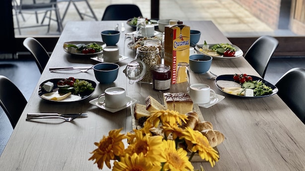 Ruokapöytä on katettu erilaisilla ruokalajeilla, kuten salaateilla, leivällä ja Choclitel-suklaarasialla.