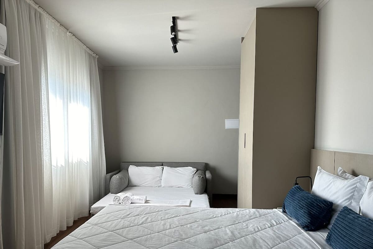 Ein Hotelzimmer mit Bett, Fernseher und Deckenleuchte.