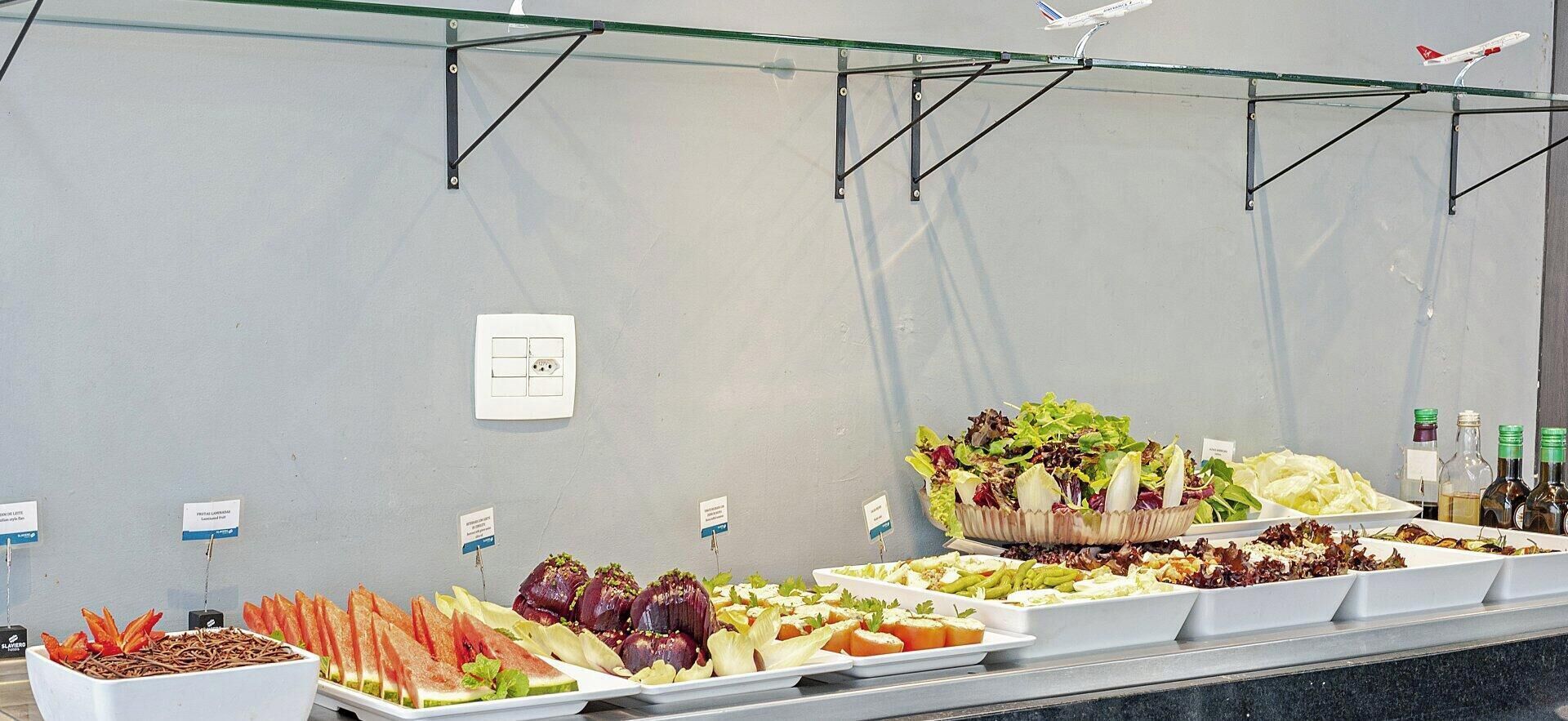 Un bufé con diversas opciones de comida y ensaladeras.