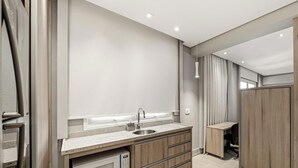 Una cocina moderna con horno empotrado, un lavamanos y un armario de madera.