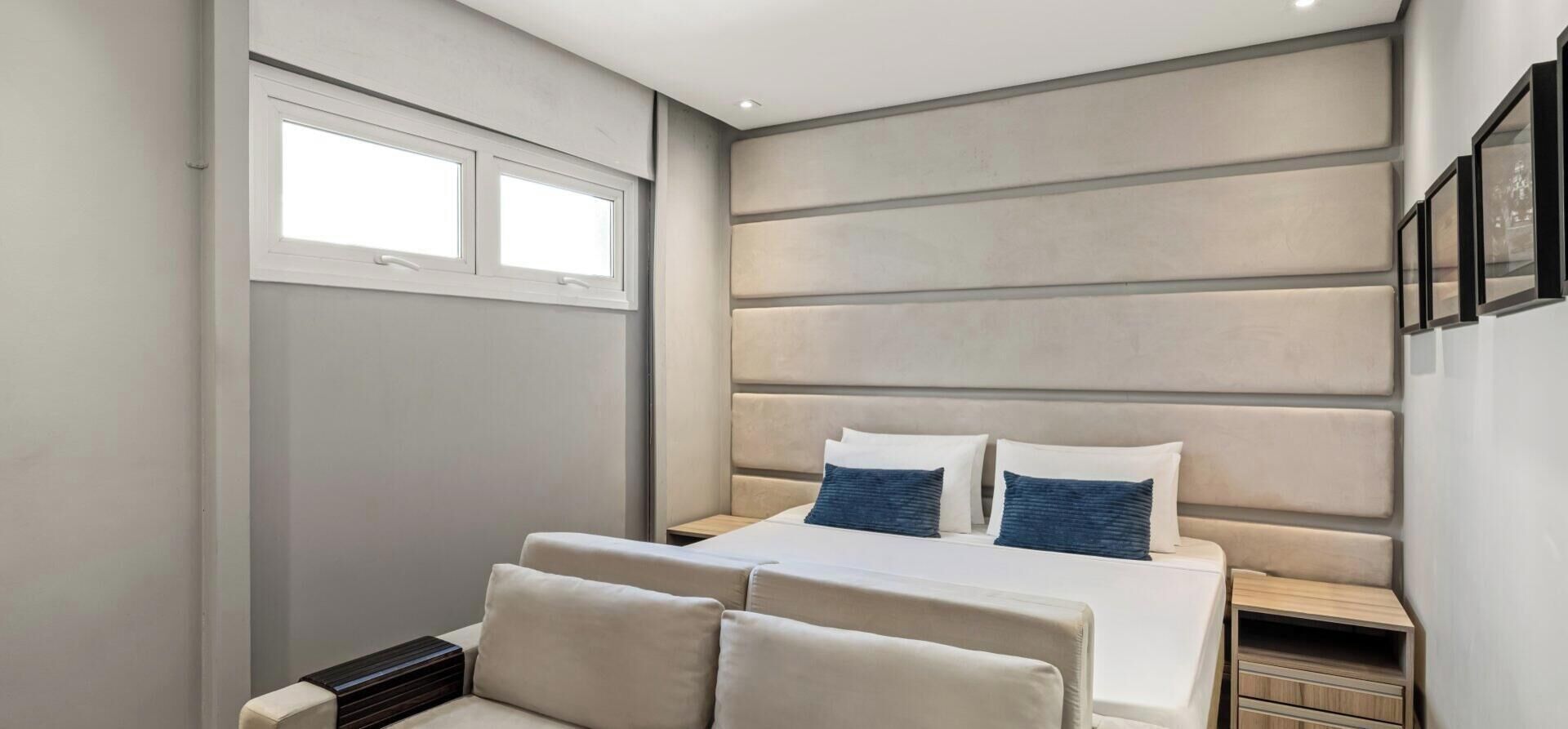 Un dormitorio moderno con una cama grande, dos mesitas de noche y una ventana.