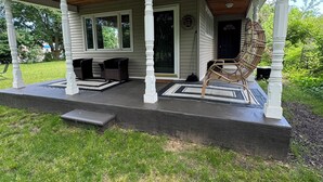 A house with a covered porch, a wooden ceiling, and a black and white patterned rug. - Bright Boho Walkable House Bars Beaches Bike Path Downtown (Muskegon)