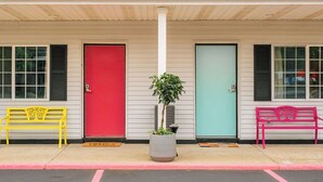 A row of colorful doors with benches in front. - The Sierra Motel (Traverse City)