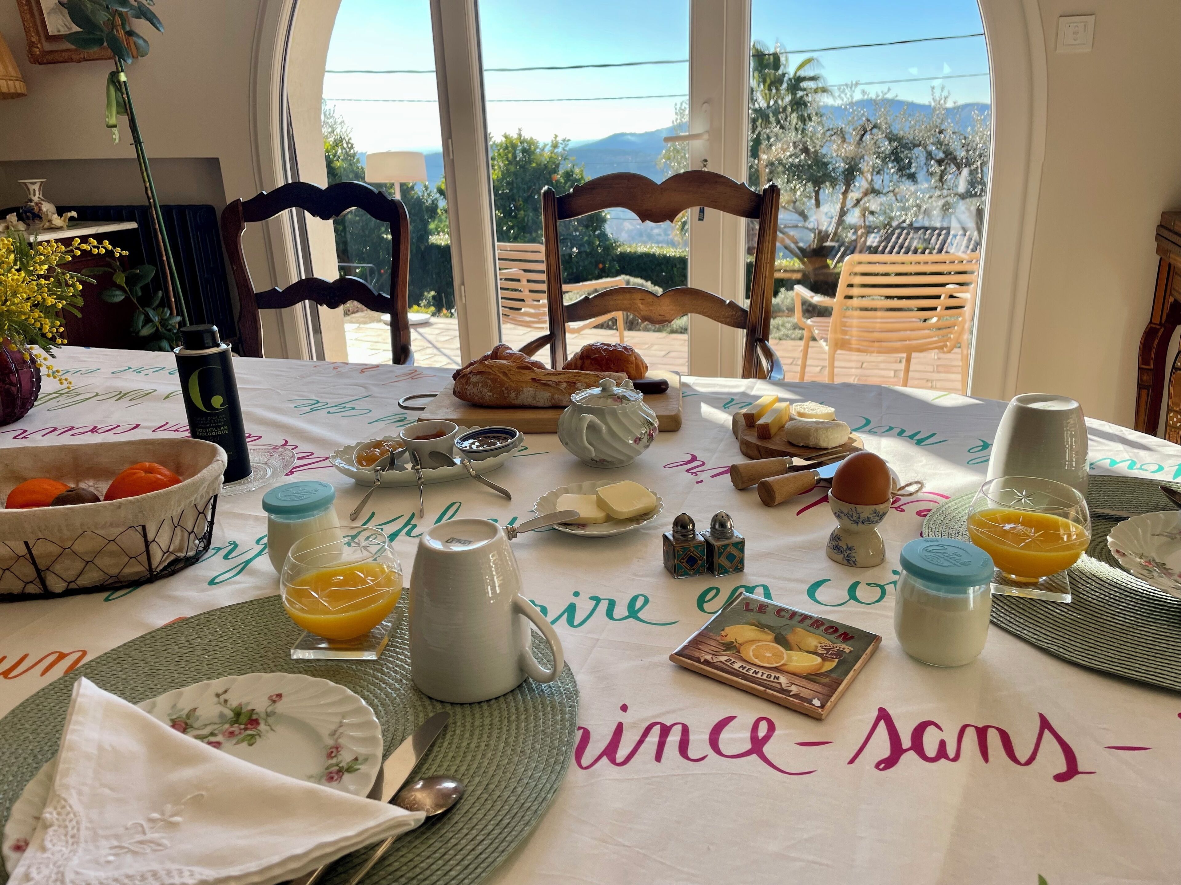 A breakfast table with various food items, a bottle, and a book titled "Le Citron".
