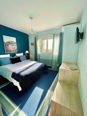 Relax in this serene bedroom with a large bed and flat-screen TV.