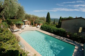 Relax by the serene pool surrounded by lush greenery and mature trees.