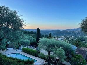 Enjoy a serene retreat with a garden, patio, and pool overlooking a panoramic view of the surrounding town.